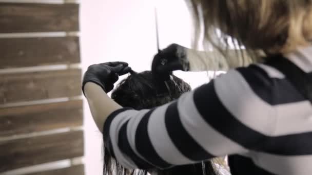 Coloração do cabelo em um salão de beleza, jovem mulher senta-se em uma poltrona — Vídeo de Stock