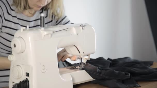Naaister draad in de naald van de naaimachine, naaimachine en vrouw handen — Stockvideo