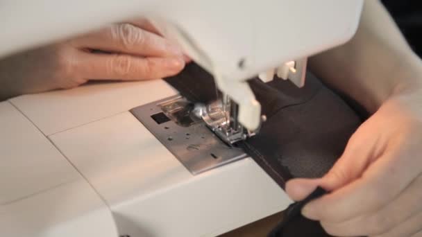 Naaister draad in de naald van de naaimachine, naaimachine en vrouw handen — Stockvideo