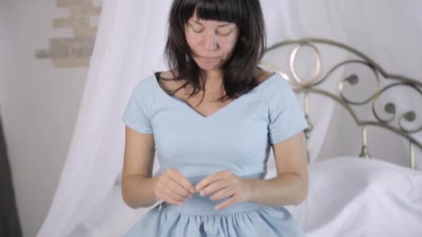 Aantrekkelijke jonge vrouw in blauwe jurk hebben een goede tijd in bed — Stockvideo