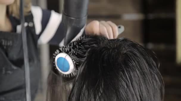 Parrucchiere professionista fa hair styling per bella cliente femminile e asciugacapelli usato con pettine — Video Stock
