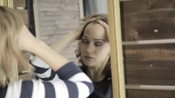 Kapper masseert haar hoofd voor spiegel met zijn ogen sluiten — Stockvideo