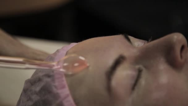Hermosa mujer tiene un procedimiento de masaje darsonval eléctrico en una oscuridad — Vídeo de stock