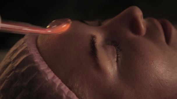 Красивая женщина имеет электрический дарсонвальный массаж процедуры в темноте — стоковое видео