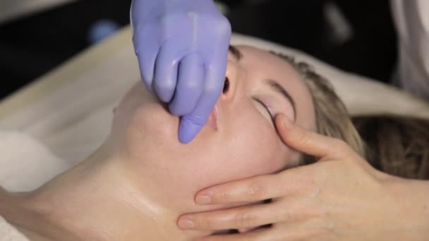 Konturenplastik. Kosmetikerin macht Lippenmassage für schöne Frau im Schönheitssalon — Stockvideo
