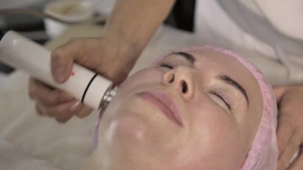 Jeune femme en traitement de la peau. Amélioration du look sans chirurgie. RF- levage sur un visage — Video