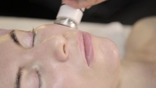 Tratamiento de radiofrecuencia. esteticista hace rf-lifting procedimiento para una mujer en un salón de belleza . — Vídeos de Stock