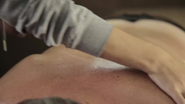 Massage schraper gouache op een mannelijke rug — Stockvideo