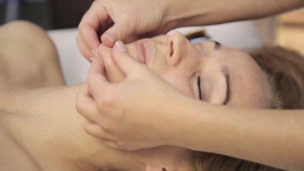 Μασέρ κάνει acupressure σε ένα γυναικείο πρόσωπο. Κινεζική εναλλακτική ιατρική — Αρχείο Βίντεο