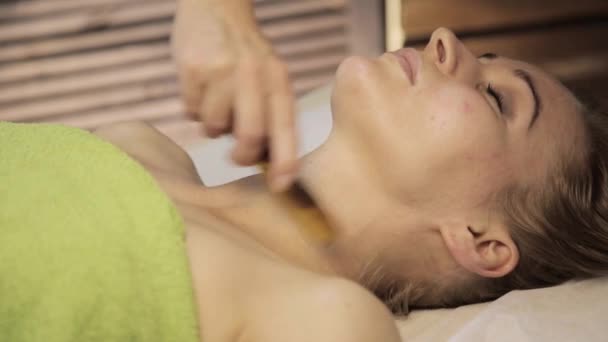 Gouache rascador de masaje. masajista hace acupresión en una cara femenina. Medicina alternativa china — Vídeo de stock