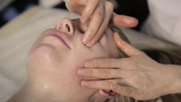 Szép nő, egyre arc masszázs. ujj masszázs olaj: a beauty Spa. — Stock videók