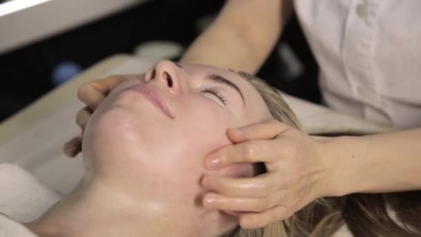 Bella donna che si fa massaggiare il viso. massaggio alle dita con olio alla Spa di bellezza . — Video Stock