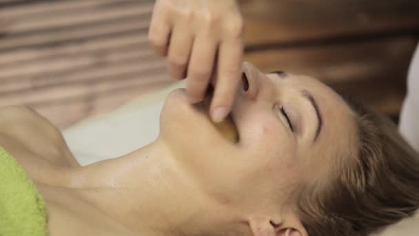Acupressão num rosto feminino. Massagem alternativa chinesa com guache raspador — Vídeo de Stock