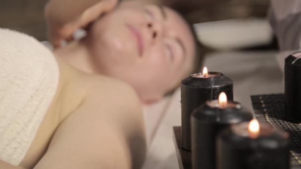 Estetista fa massaggio facciale per bella donna in salone spa . — Video Stock