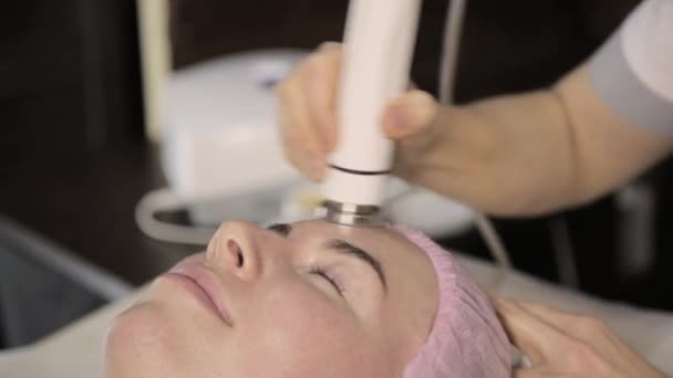 Esteticista faz rf cara procedimento de elevação para uma mulher em um salão de beleza. Cosmetologia de hardware — Vídeo de Stock