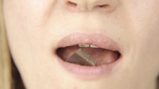 Close-up woman eating chocolate, only lips view — Stock Video