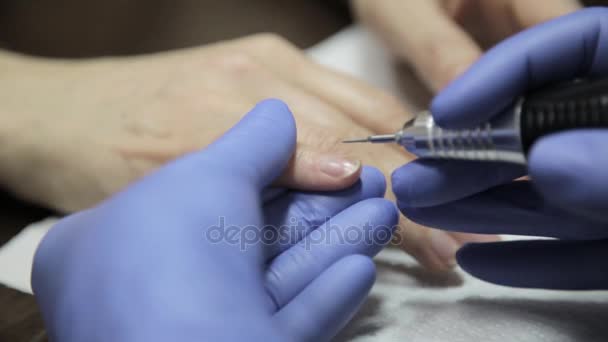 A manicura faz uma manicura em um salão de beleza de prego. mulher usando uma ferramenta de unhas para dar uma manicure . — Vídeo de Stock