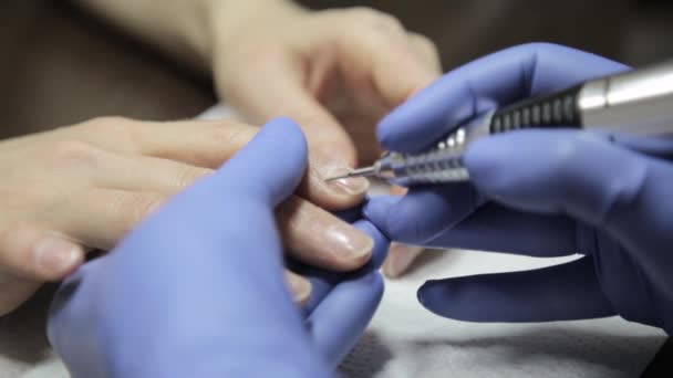 A manicura faz uma manicura em um salão de beleza de prego. mulher usando uma ferramenta de unhas para dar uma manicure . — Vídeo de Stock