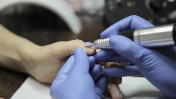 Получение процедуры удаления кутикулы с помощью ногтевых инструментов в салоне ногтей — стоковое видео