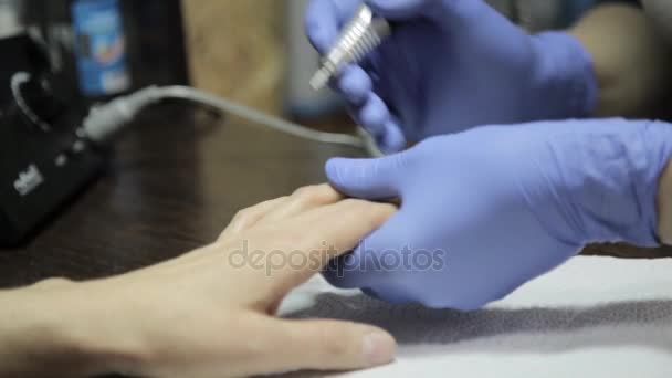 A manicura faz uma manicura em um salão de beleza de prego. mulher usando uma ferramenta de unhas para dar uma manicure . — Vídeo de Stock