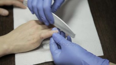 manikürcü istemciye bir güzellik salonu manikür var. yakın çekim çivi dosyalama