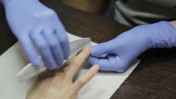 A manicura faz uma manicura ao cliente em um salão de beleza. close-up arquivamento de unhas — Vídeo de Stock