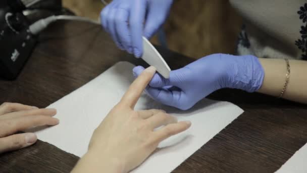 Limatura delle unghie e cura delle mani. Le mani di donna che ricevono una manicure in salone di bellezza . — Video Stock