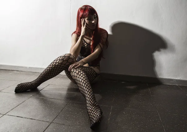 Mujer prostituta triste después del trabajo duro sentado en el suelo, medias de red de provocación — Foto de Stock