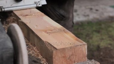 planya makinesi bir ahşap üzerine çalışan adam. Planer farklı taraftan cips sinek