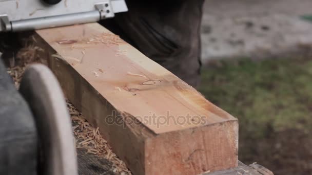 Mann arbeitet an einer Holzhobelmaschine. Späne fliegen von der Hobelmaschine auf andere Seite — Stockvideo