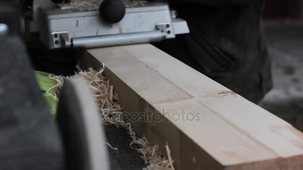 Εργαστήριο εργαζόμενοι χρησιμοποιούν ξύλο μηχανή πλανίσματος. Μάρκες που πετούν σε διαφορετική πλευρά από την πλάνη — Αρχείο Βίντεο