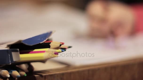 Close-up kid hands with pencil. child draws with colored pencil on paper. — Stock Video