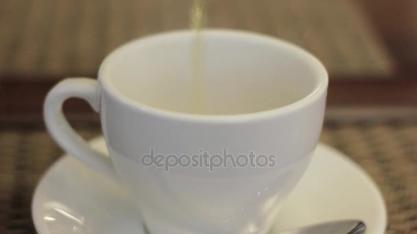 Vue de l'eau chaude versant dans une tasse blanche ou une tasse avec un fond flou 