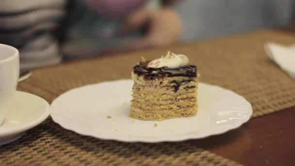 Vrouw die een prachtige, smakelijk stuk taart eten bij café. inname van een fluitje van een cent met een vork — Stockvideo