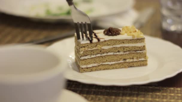 Una mujer comiendo un hermoso y apetitoso pastel en el café. tomar un pedazo de pastel con un tenedor — Vídeos de Stock