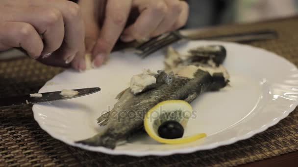 Femme manger du poisson avec ses mains sur une assiette blanche dans un café — Video