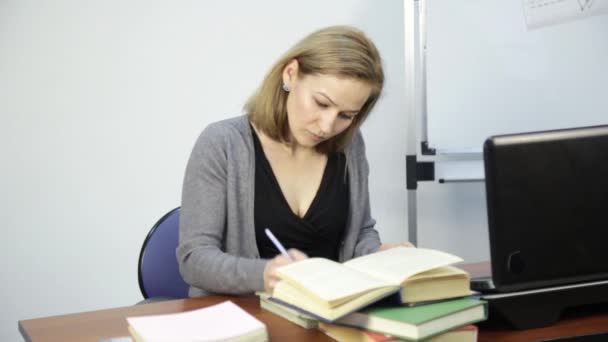 Žena učitel zkontroluje domácí úkol v učebně u notebooku — Stock video