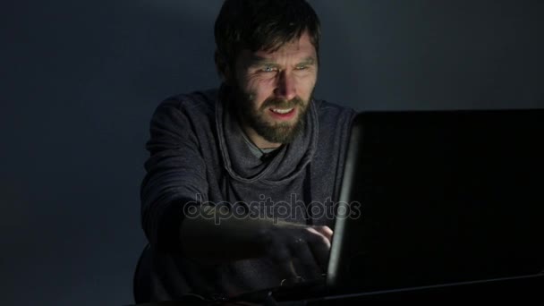 Hombre barbudo frustrado trabajando en el ordenador portátil y comienza a regocijarse — Vídeos de Stock