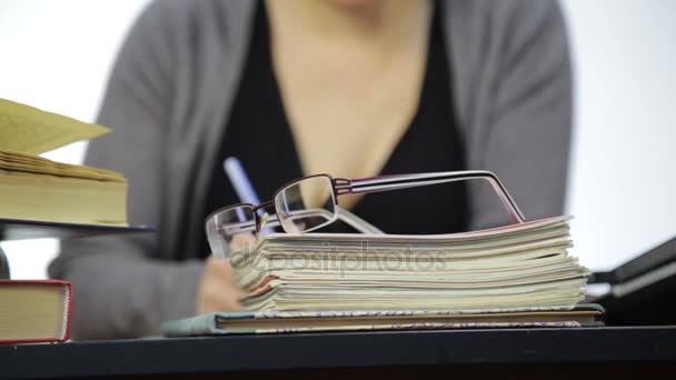 Крупним планом окуляри на тренувальних книгах, вчитель працює без окулярів після корекції зору — стокове відео