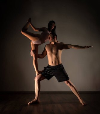 Karanlık bir odada acroyoga egzersizleri yapıyor genç spor Çift