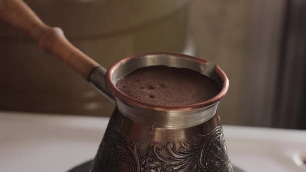 Förbereder traditionellt turkiskt kaffe i koppar kastrull över spis — Stockvideo