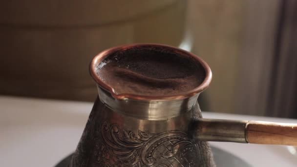 Bereitet traditionellen türkischen Kaffee in Kupferkanne über Herd zu — Stockvideo