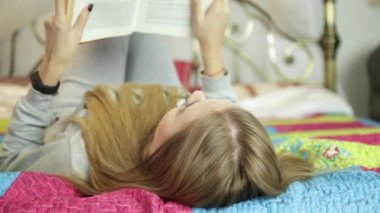 genç kadın evde öğrenme. Kız bir yatak üzerine bir kitap okuma