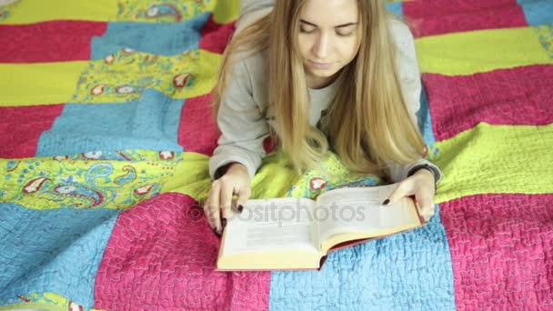 Beautiful young woman reading a book on a bed at home. learning at home. — Stock Video