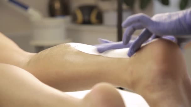 Cosmetologist κάνει αποτρίχωση με κερί με βαμβάκι λουρίδες θηλυκό πελάτη — Αρχείο Βίντεο