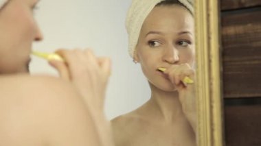 Banyoda dişlerini fırçalama bir kafa havluya olan güzel kadın