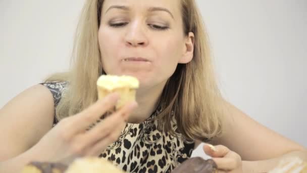 Nahaufnahme Frau isst Cupcakes im Rausch nach kräftezehrender Ernährung — Stockvideo