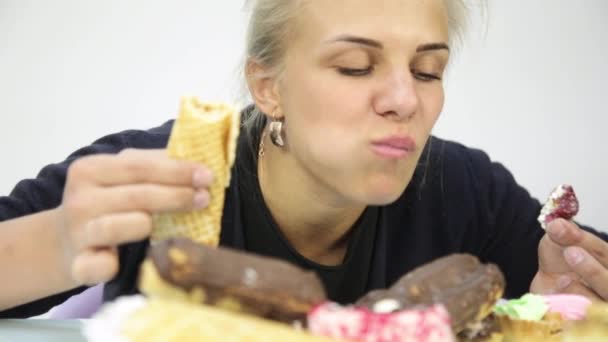 Nahaufnahme Frau isst Cupcakes im Rausch nach kräftezehrender Ernährung