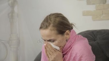 hasta bir kadın bir peçete kullanarak burnunu siliyor ve yüksek sesle hapşırma