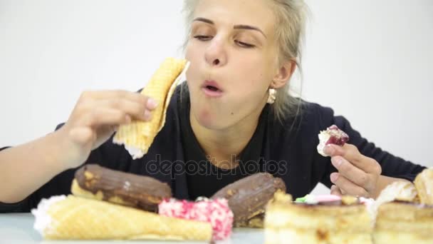 Žrout žena jíst cupcakes s šílenství po dlouhé dieta — Stock video